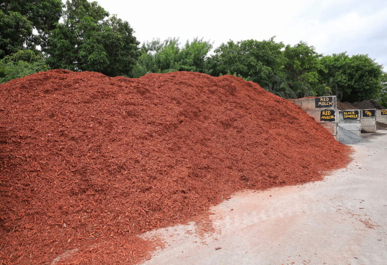Large pile of red colored wood mulch at an outdoor products yard